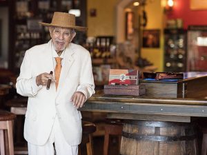 avo-uvezian-standing-at-bar-table-cigar-boxes