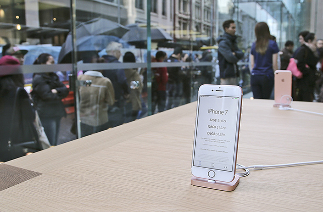 Customers line up out in the rain to purchase the new iPhone 7 or 7 Plus at the Apple store in Sydney, Australia, Friday, Sept. 16, 2016. The latest iPhone was released in the country on Friday. (AP Photo/Rob Griffith)