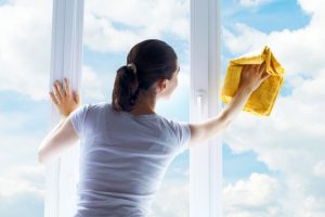 Young woman washing windows