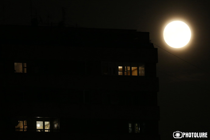 The supermoon is seen behind a building under construction in Yerevan, Armenia