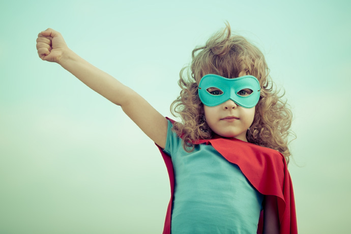 Superhero kid against summer sky background. Girl power and feminism concept